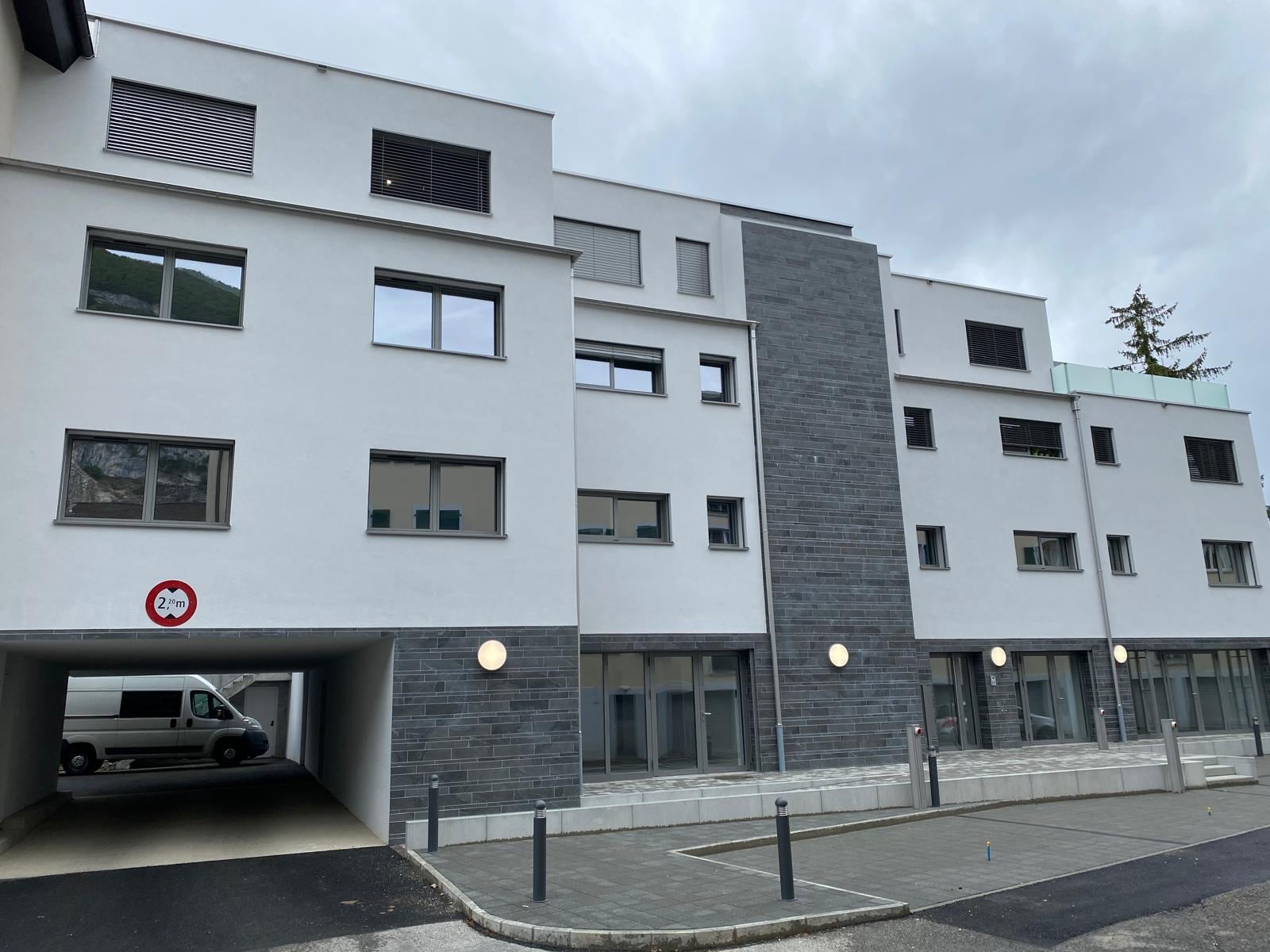 Immeuble terminé : entrée du parking et garde-corps vitrés en attique — Sous-Balme, Veyrier (GE)