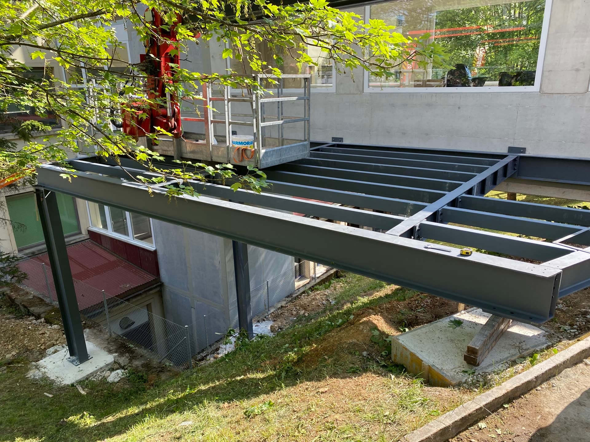 Ossature en poutrelles d’acier sur poteaux et semelles béton, accolée au bâtiment — Rue des Roches, Saint-Imier (BE)